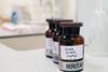 Three brown glass vials labelled as containing silver nitrate on a white-grey laboratory bench