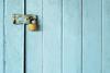 Metal padlock on blue door
