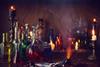 Lit candles and a spooky selection of bottles holding coloured liquids