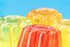 Four brightly coloured jellies against a light blue background