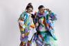 Man and woman fashionistas dressed a=in bright plastic waste and wearing sunglasses