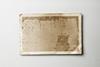 A piece of old photographic paper, creased and discoloured