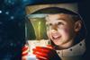Child in a spacesuit looking at a plant