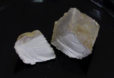 A photograph of sodium metal on a black dish