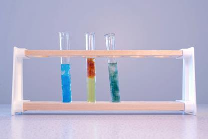 A photograph of three test tubes in a test tube rack, each containing a different colour of precipitate including copper hydroxide, iron(III) hydroxide and iron(II) hydroxide