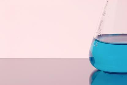 A photograph of a conical flask containing blue copper(II) sulfate solution