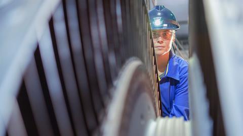 A female engineer inspects a turbine in a nuclear power plant