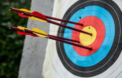 Four arrows embedded in an archery target